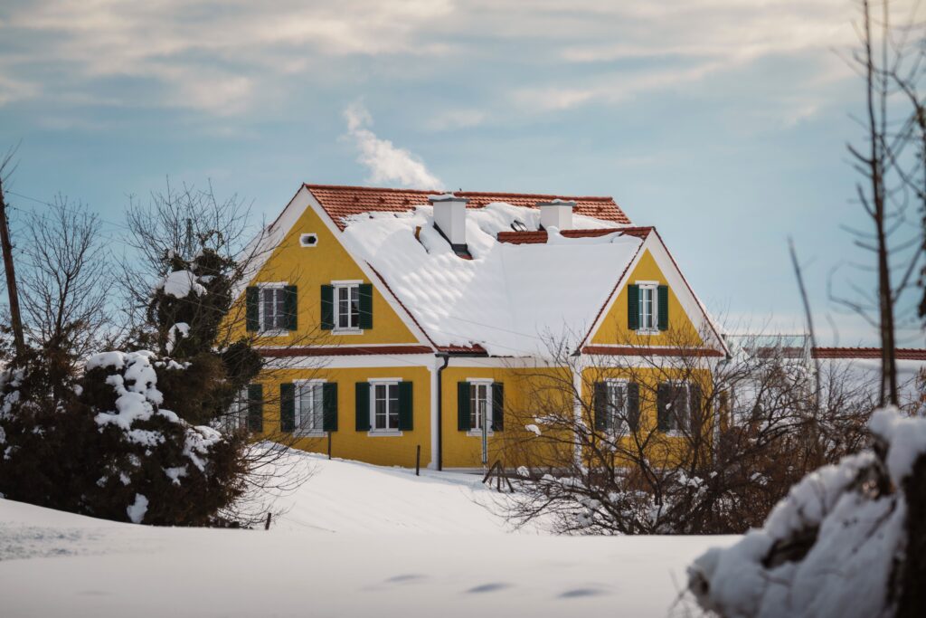 A picturesque yellow house in Teichalm, Austria, covered in winter snow, creates a warm retreat.